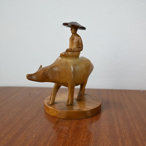 Vintage wooden carving of a man on a buffalo used