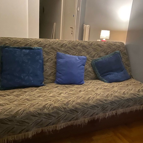 Three-seater sofa used with throw and cushions