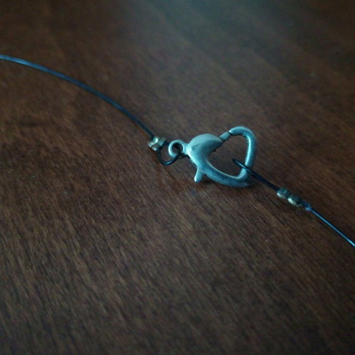 Pendant perforated sphere with heart clasp on leather strap used
