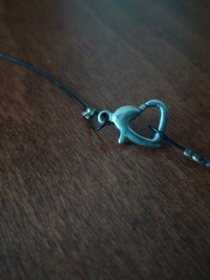 Pendant perforated sphere with heart clasp on leather strap used