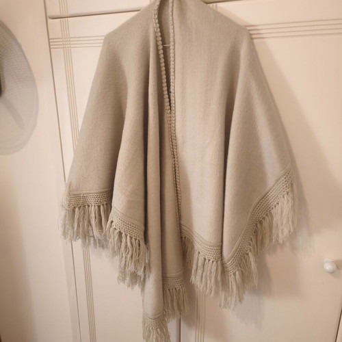 Knitted women's cape 100% wool, beige with fringes
