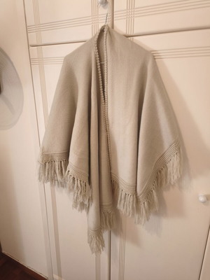 Knitted women's cape 100% wool, beige with fringes