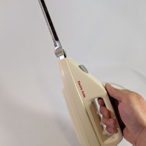 Electric kitchen knife used with 2 double serrated blades and wall mount