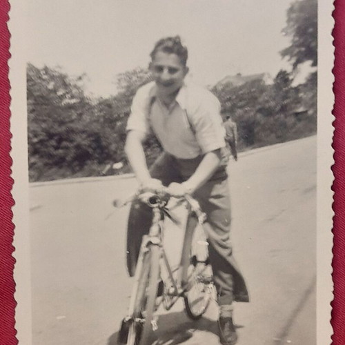 Vintage black and white photo of man with bicycle, scalloped edge