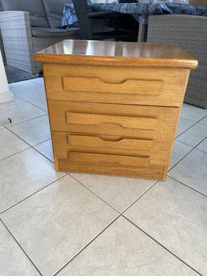 Classic wooden bedside table with three drawers used