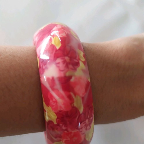 Bracelet asymmetric with pink flowers and green leaves on red background
