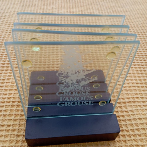 The Famous Grouse collectible glass coaster set with black ribbed base
