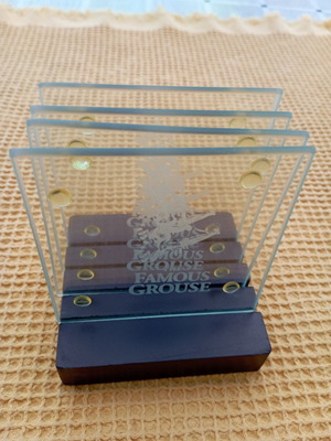 The Famous Grouse collectible glass coaster set with black ribbed base