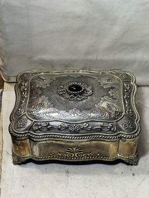 Vintage metal jewelry box with embossed designs and black stone, used