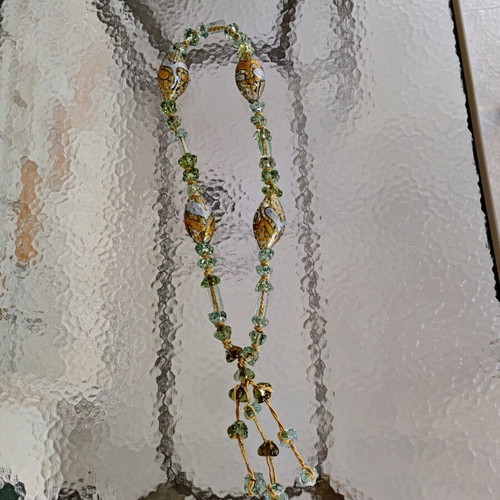 Tabletop komboloi with green and gold glass beads