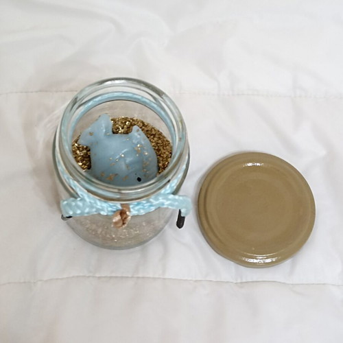 Decorative jar with candle fish and golden sand