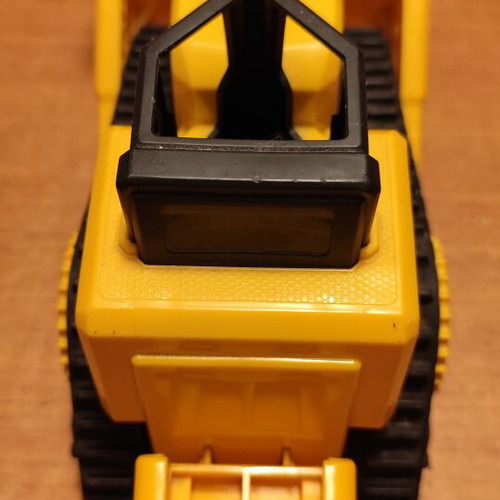 CAT bulldozer toy used with moving tracks and gradual forward-back motion