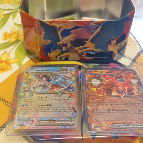 Charizard tin set like new with 50 common, 20 holos and 2 ex Pokémon cards