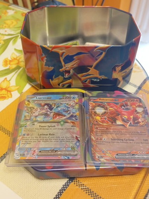 Charizard tin set like new with 50 common, 20 holos and 2 ex Pokémon cards