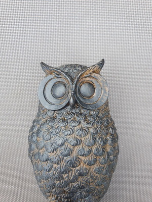 Decorative owl figurine with detailed feathers and pedestal base