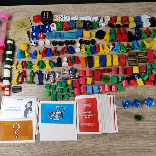 Lot of used board game parts including pawns, dice, cards, and hourglasses