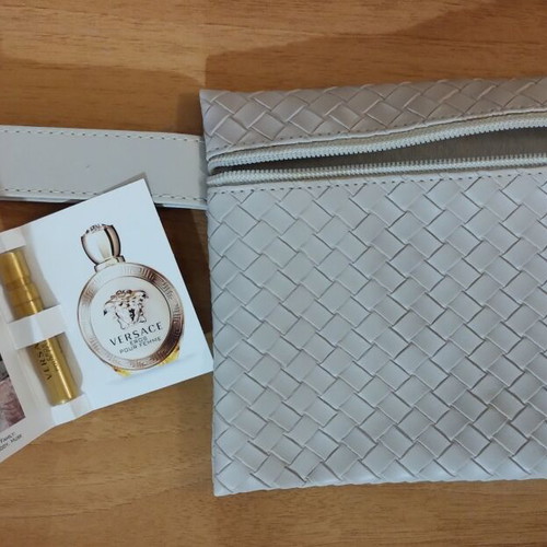 Everyday beige toiletry bag with woven texture and Versace Eros Pour Femme perfume sample