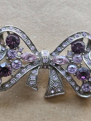 Metal bow-shaped brooch with stones like new, purple and silver