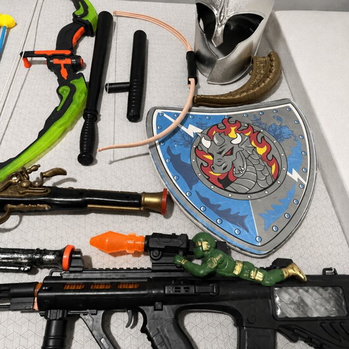Children's toy weapons set including nerf guns, swords, bows, and truck race track