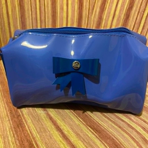 Shiny blue toiletry bag with decorative bow, like new
