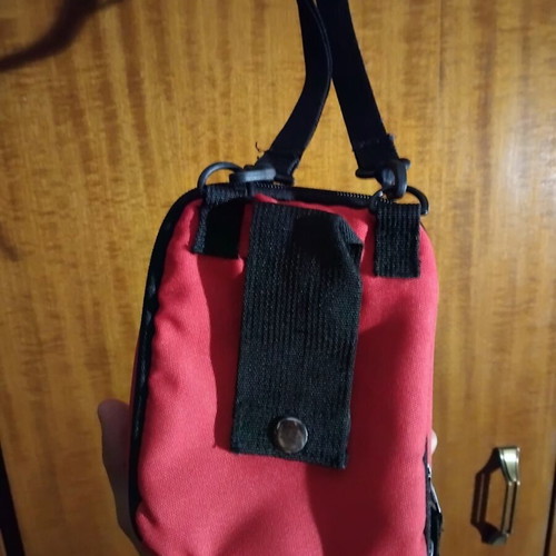 Small red shoulder bag used with multiple compartments