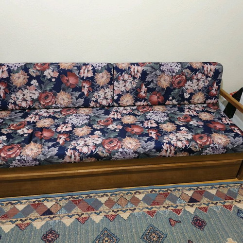 Three-seater sofa with pull-out bed and floral upholstery