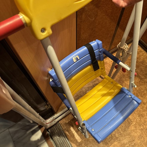 Children's swing with seat and safety straps used