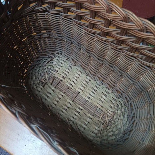 Handmade dark brown wicker basket with high arched handle
