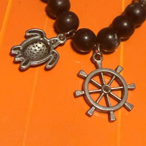 Elastic bracelet like new with steering wheel and turtle charms black-silver