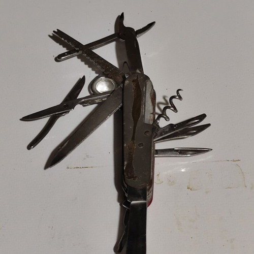 Multitool pocket knife used with red handle and multiple foldable tools