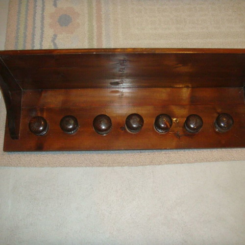 Wooden wall-mounted hat rack with seven hooks used