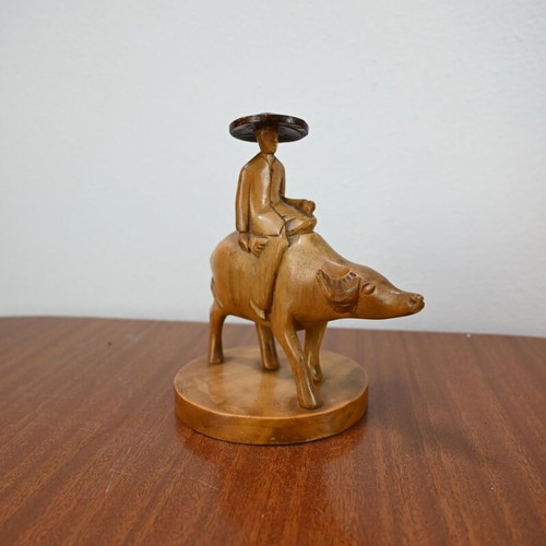 Vintage wooden carving of a man on a buffalo used