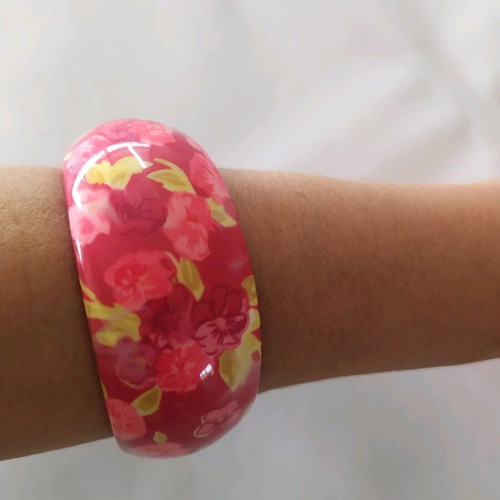 Bracelet asymmetric with pink flowers and green leaves on red background
