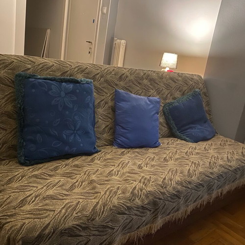 Three-seater sofa used with throw and cushions