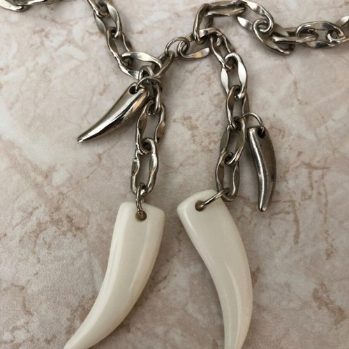 Necklace with plastic and metal fangs