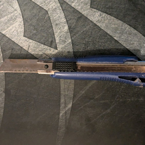 Blue utility knife used with broken back edge