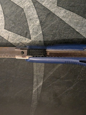 Blue utility knife used with broken back edge