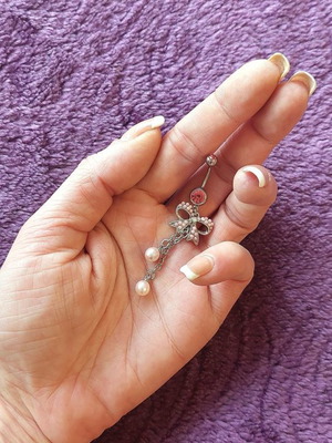 Girlie navel piercing with pink details and bow