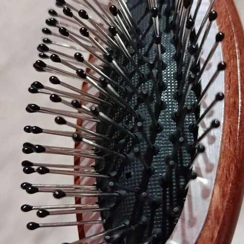 Small hairbrush with metal pins and rubber cushion