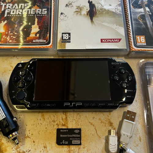 Sony PSP-2004 console with 8 game cartridges and accessories set
