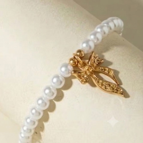 Elastic bracelet with pearls and gold bow charm