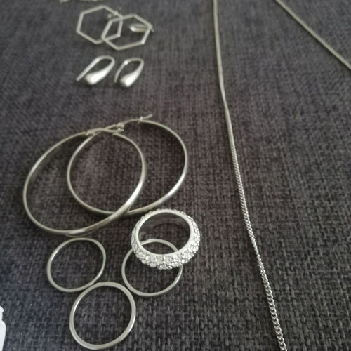 Various silver jewelry including earrings, body chain, rings, and necklace