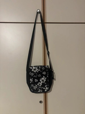 Черна чанта тип кросбоди с бял флорален дизайн като нова