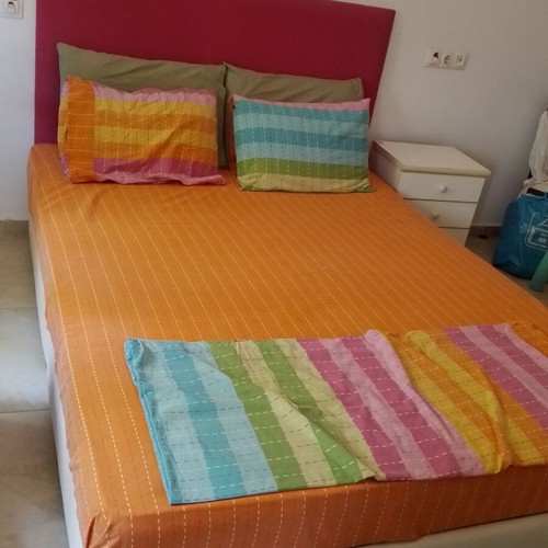 Double bed with fuchsia headboard, wooden support boxes and mattress
