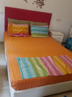 Double bed with fuchsia headboard, wooden support boxes and mattress