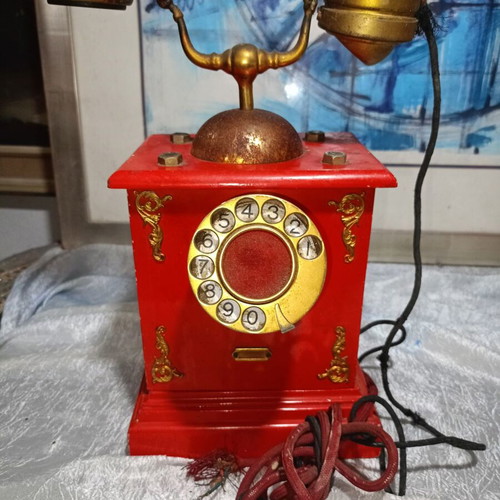 Vintage metal rotary phone, red with gold details