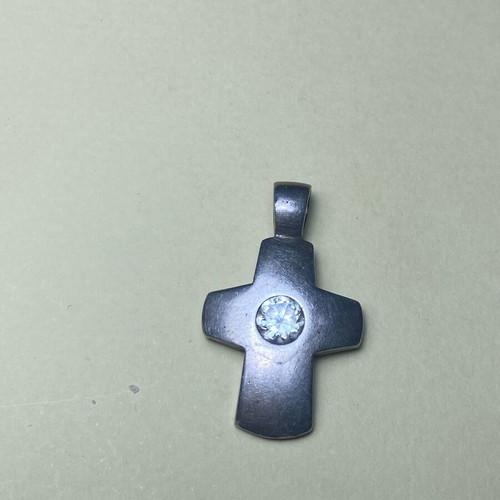 Silver cross used with stone