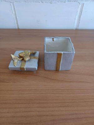 Ceramic gift-shaped box used with signs of wear