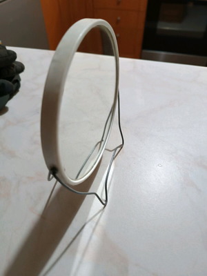 Small round tabletop mirror used with integrated stand