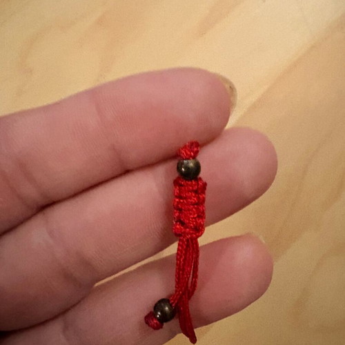 Red bracelet with cross and evil eye charm